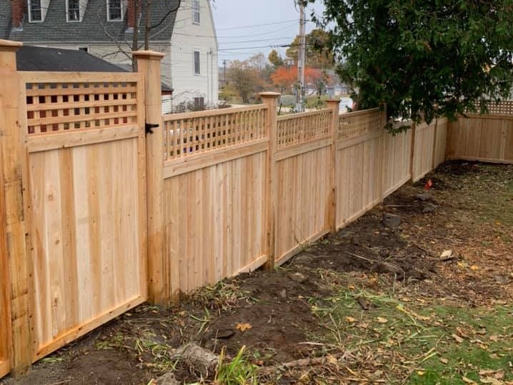 Photo of a semi-private wood fence with lattice top on a stepped grade