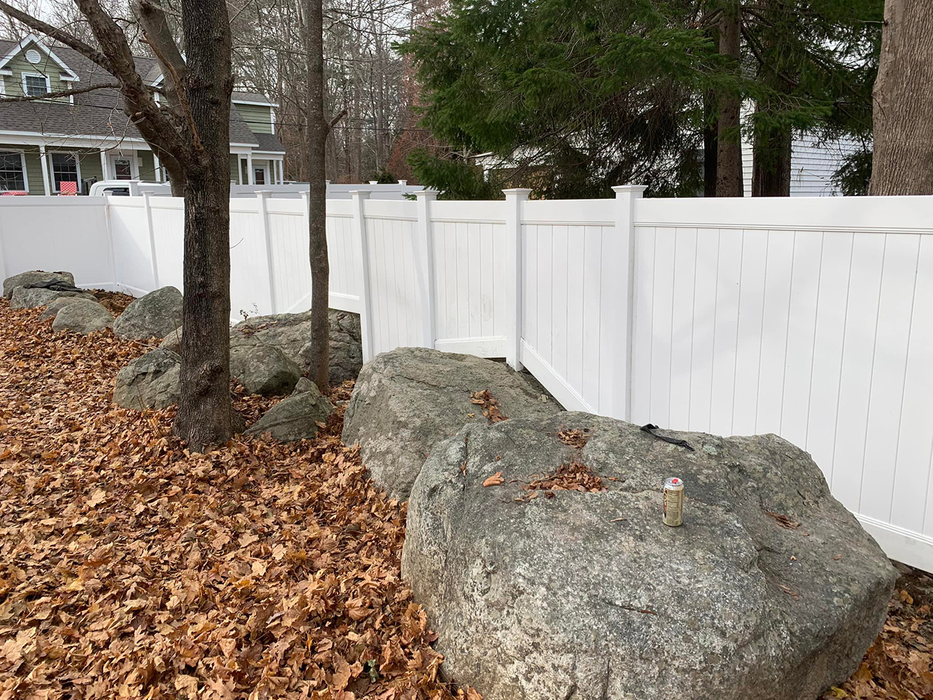 A photo of a white vinyl privacy fence